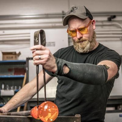 angus powers working with a blown glass piece