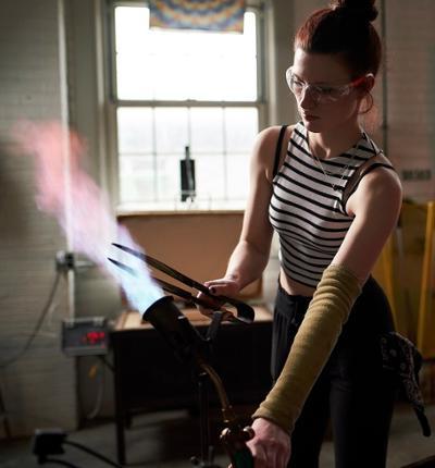 student torching glass